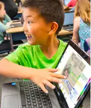 excited boy showing something on a laptop screen