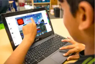 student pointing to screen on laptop