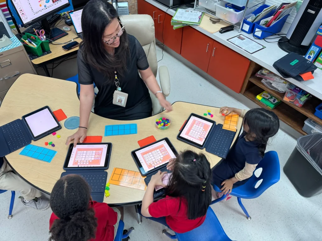 Teacher working with students in small groups on Seesaw in Garland ISD