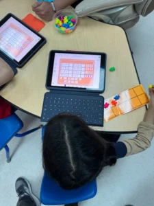 Elementary school student uses math manipulatives and Seesaw