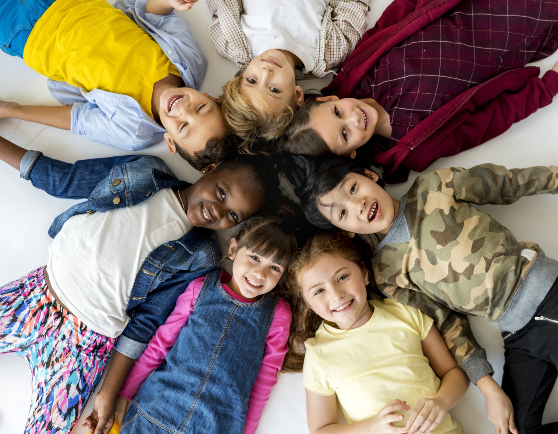 Elementary students laying on the ground in a circle