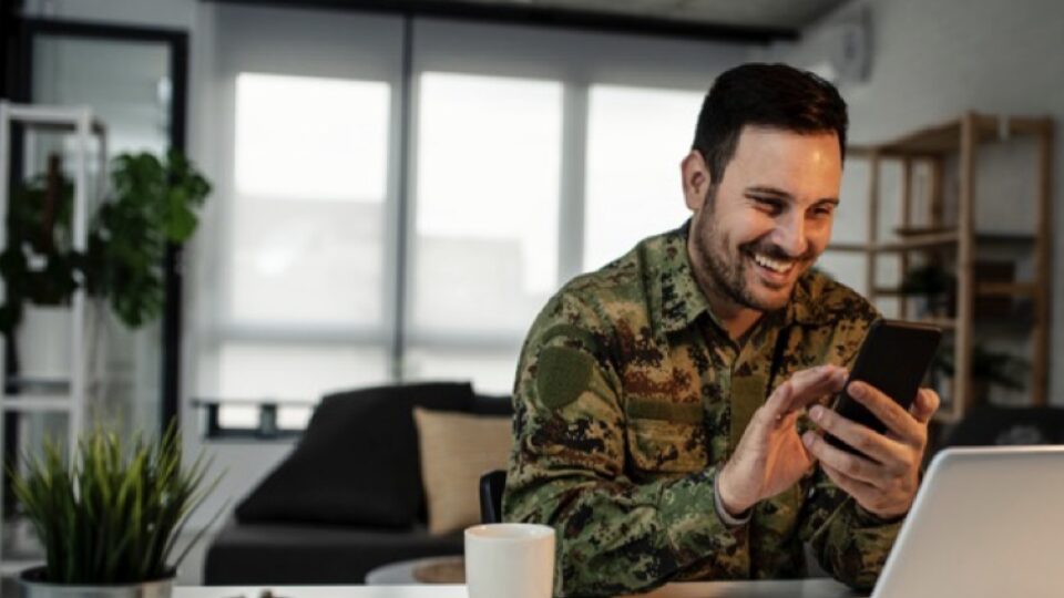 Military father checking updates on his phone