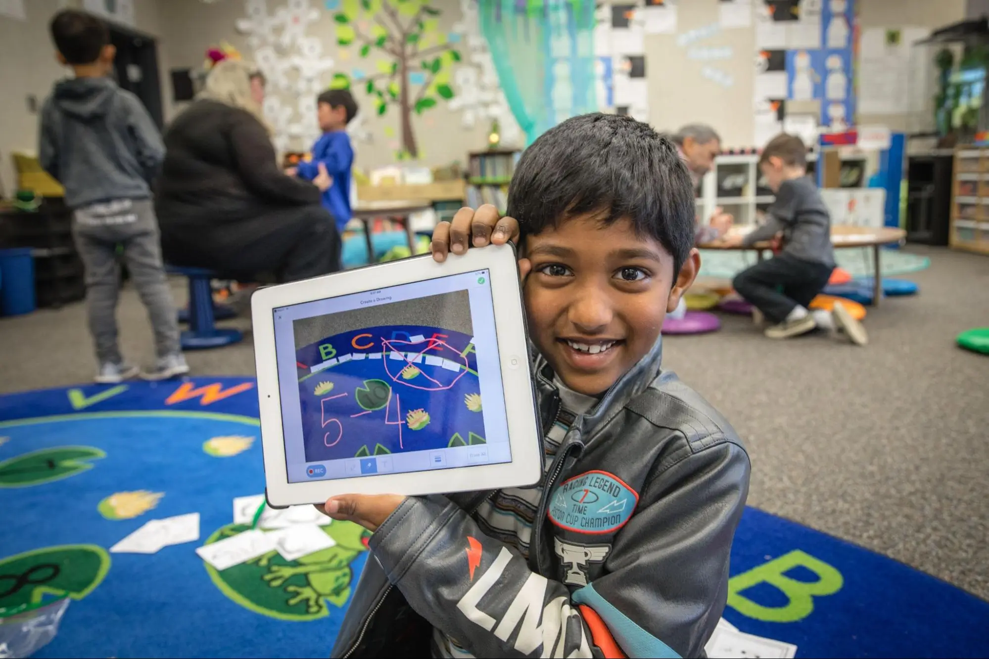 Student holding tablet smiling