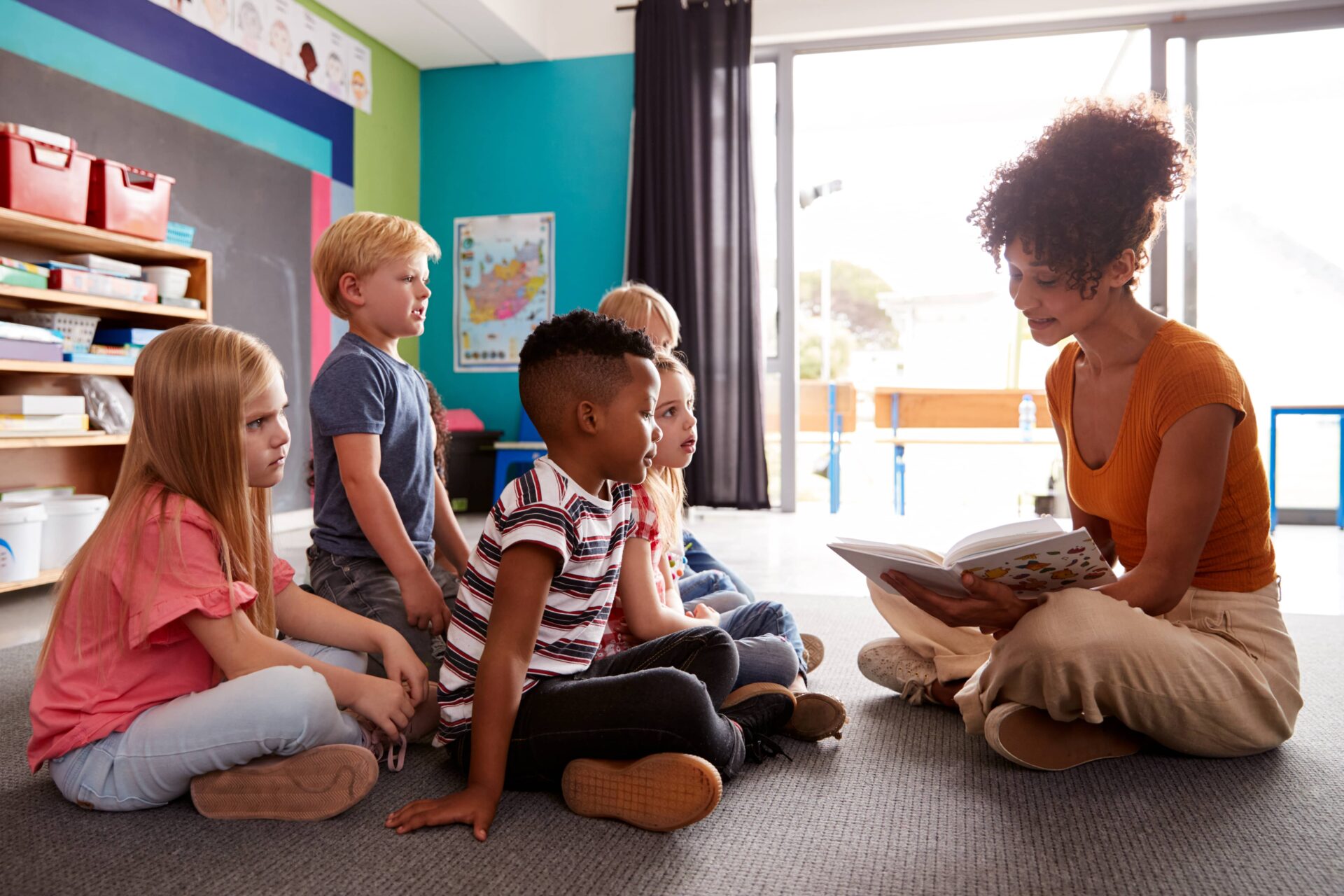 Teacher reading to students on the floor