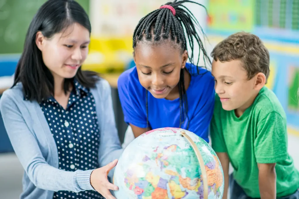 Teacher with students looking at a globe