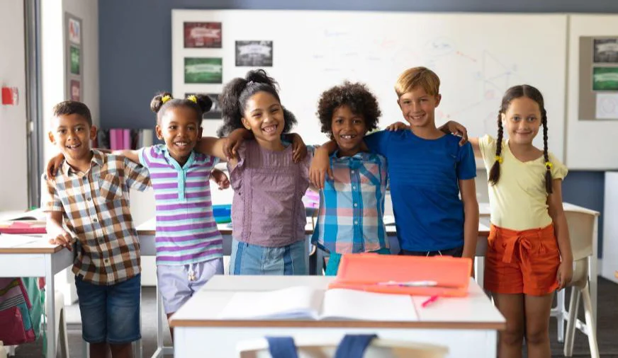 a smiling row of elementary school students