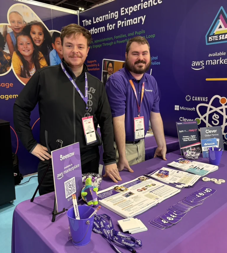 Two Seesaw employees welcome expo attendees to their table.