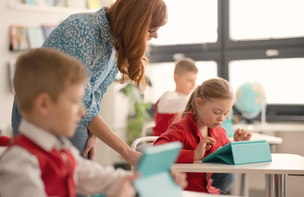 A special educational needs coordinator helps students in the classroom