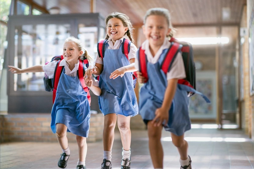 3 students running excitedly to class