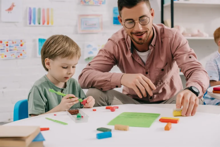 a teacher helps a student build with clay.