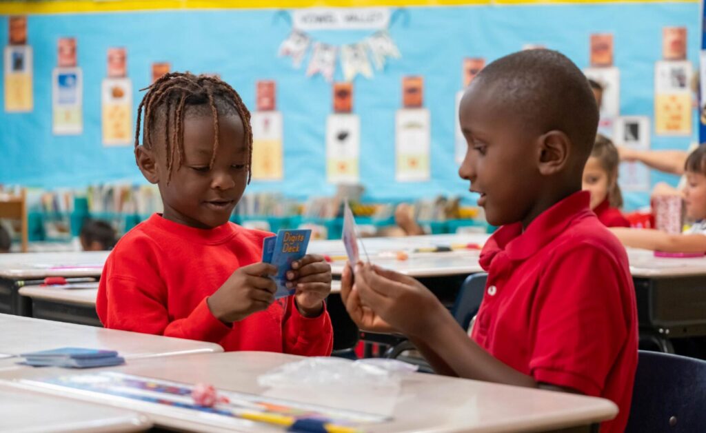 Two students compare flashcards in the classroom