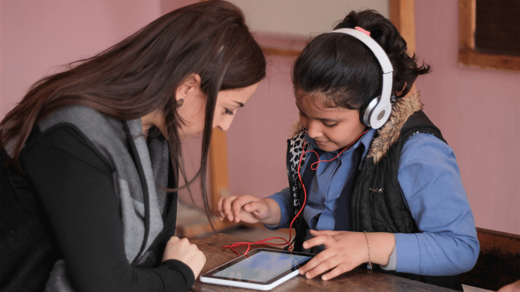 Female teacher and student using tablet in class