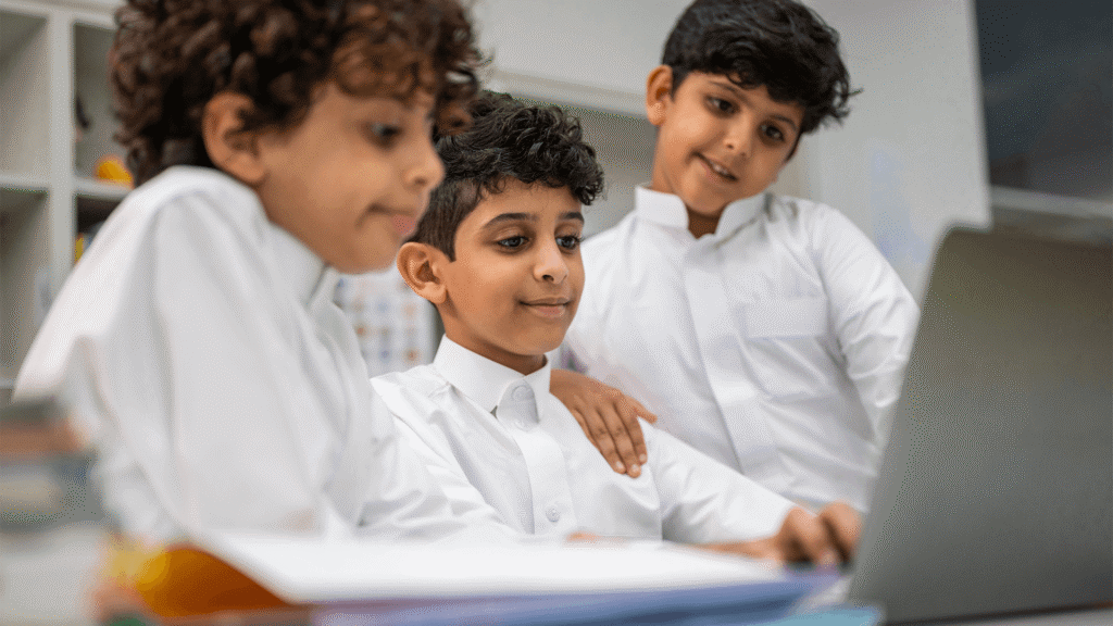 3 Arab students using laptop in school